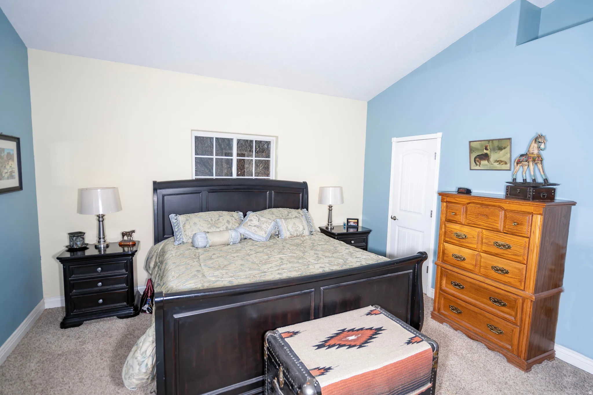 Bedroom featuring light colored carpet and lofted ceiling