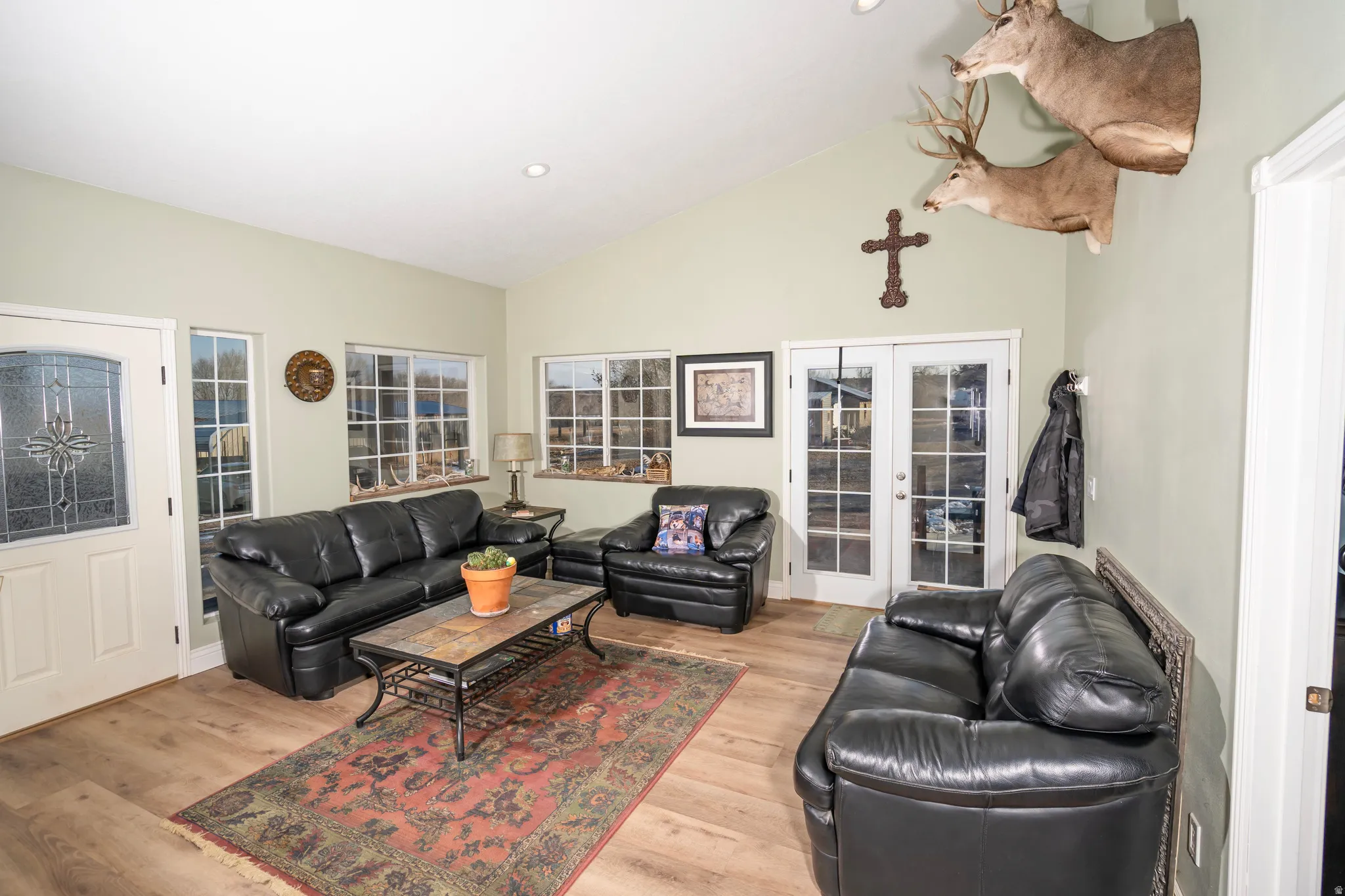 Living area with french doors, high vaulted ceiling, light wood-type flooring, and recessed lighting