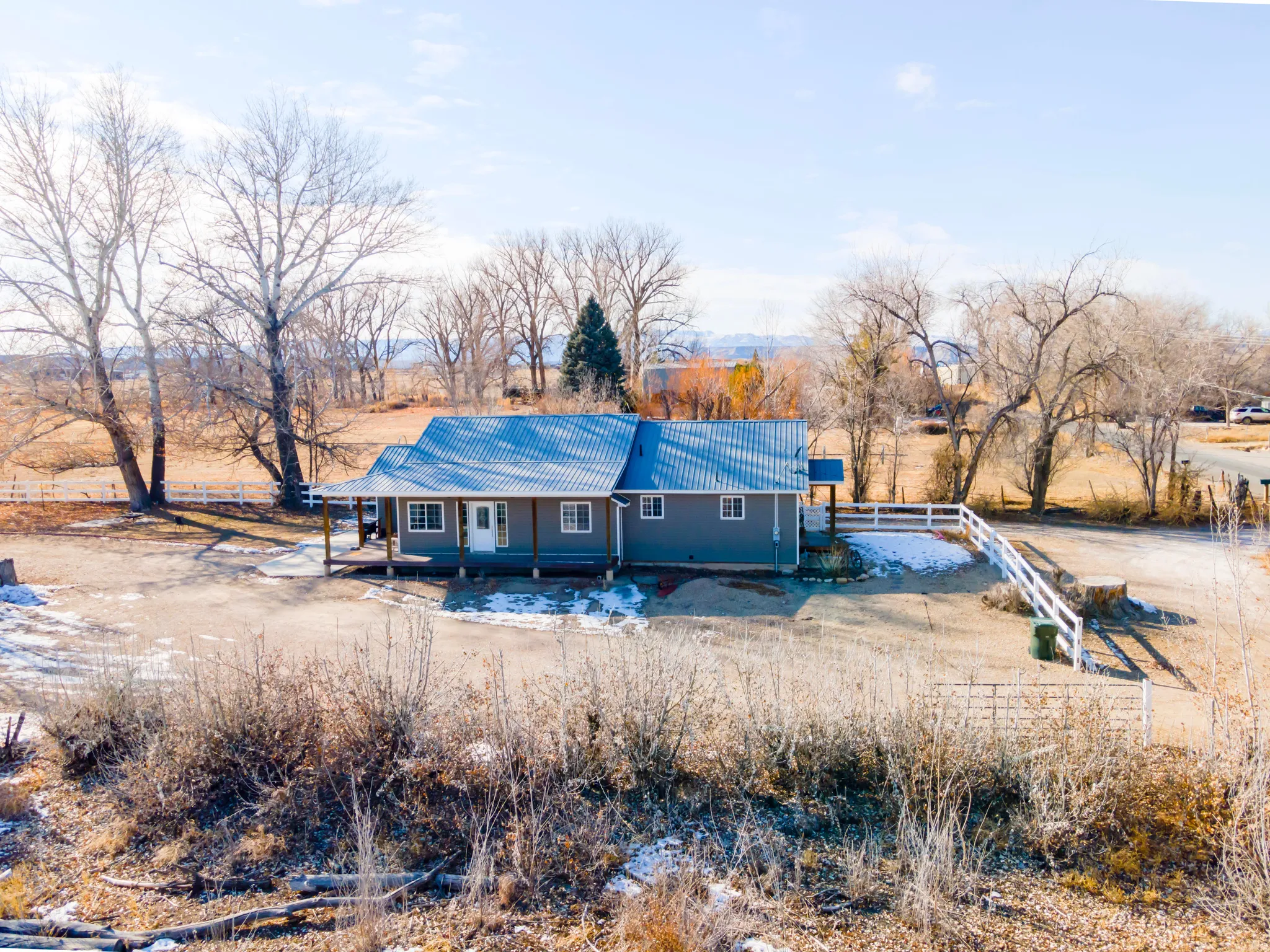 Back of house featuring a metal roof, a view of countryside, and a patio area