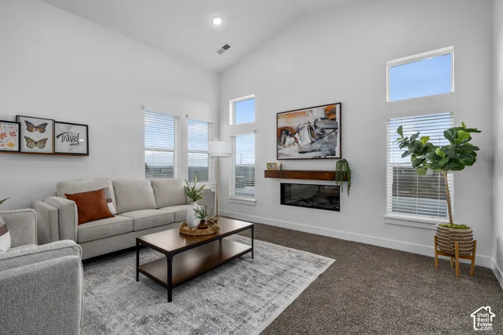 Great room with vaulted ceilings and cozy fireplace. Opens to kitchen and dining room.