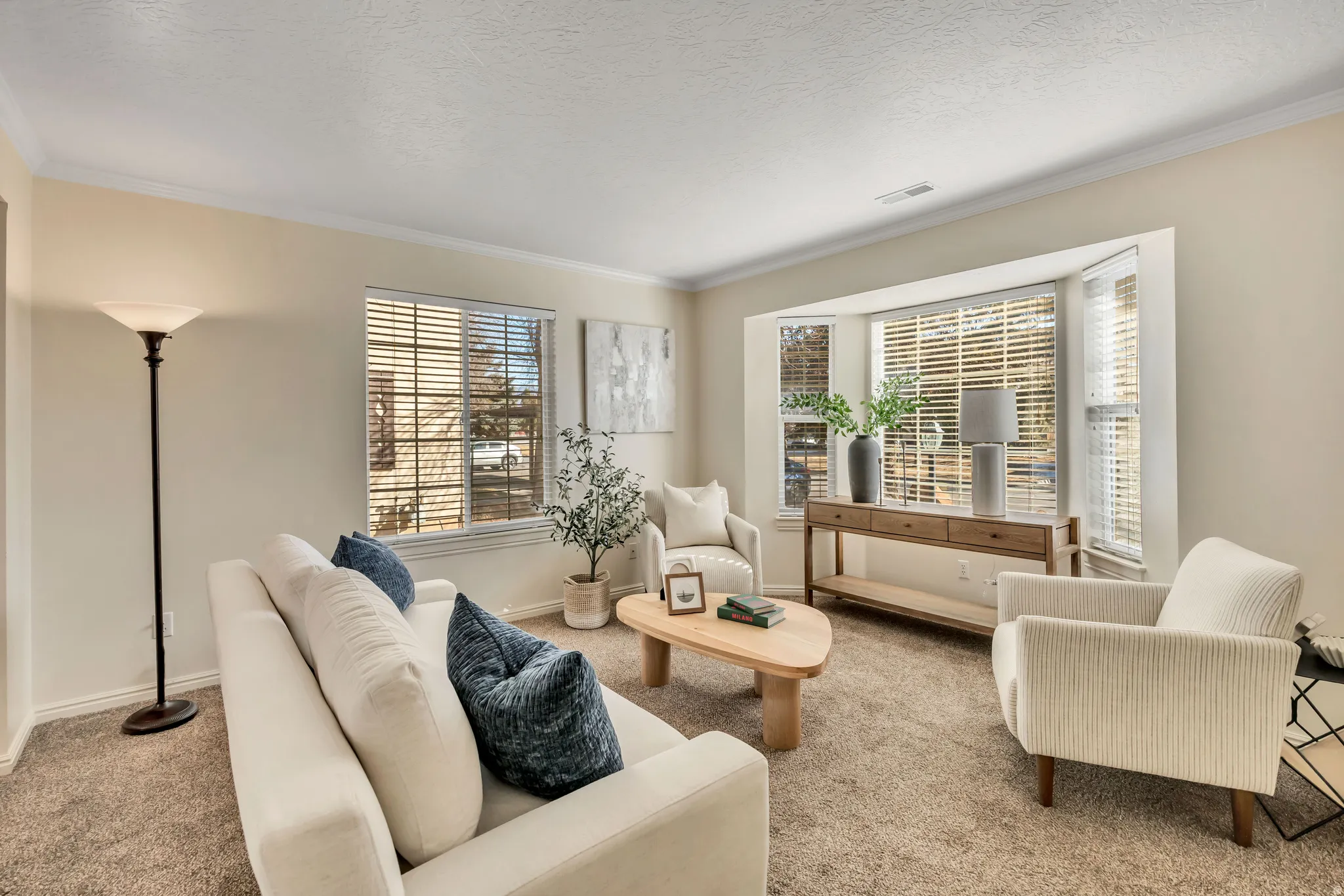 Living room with carpet flooring, crown molding, and a textured ceiling