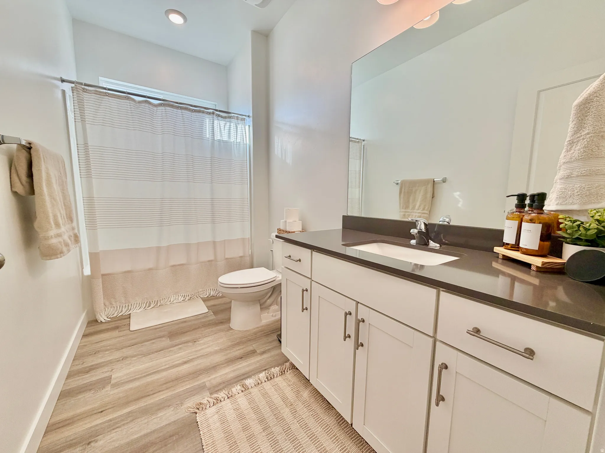Full bathroom with vanity and light wood-style flooring