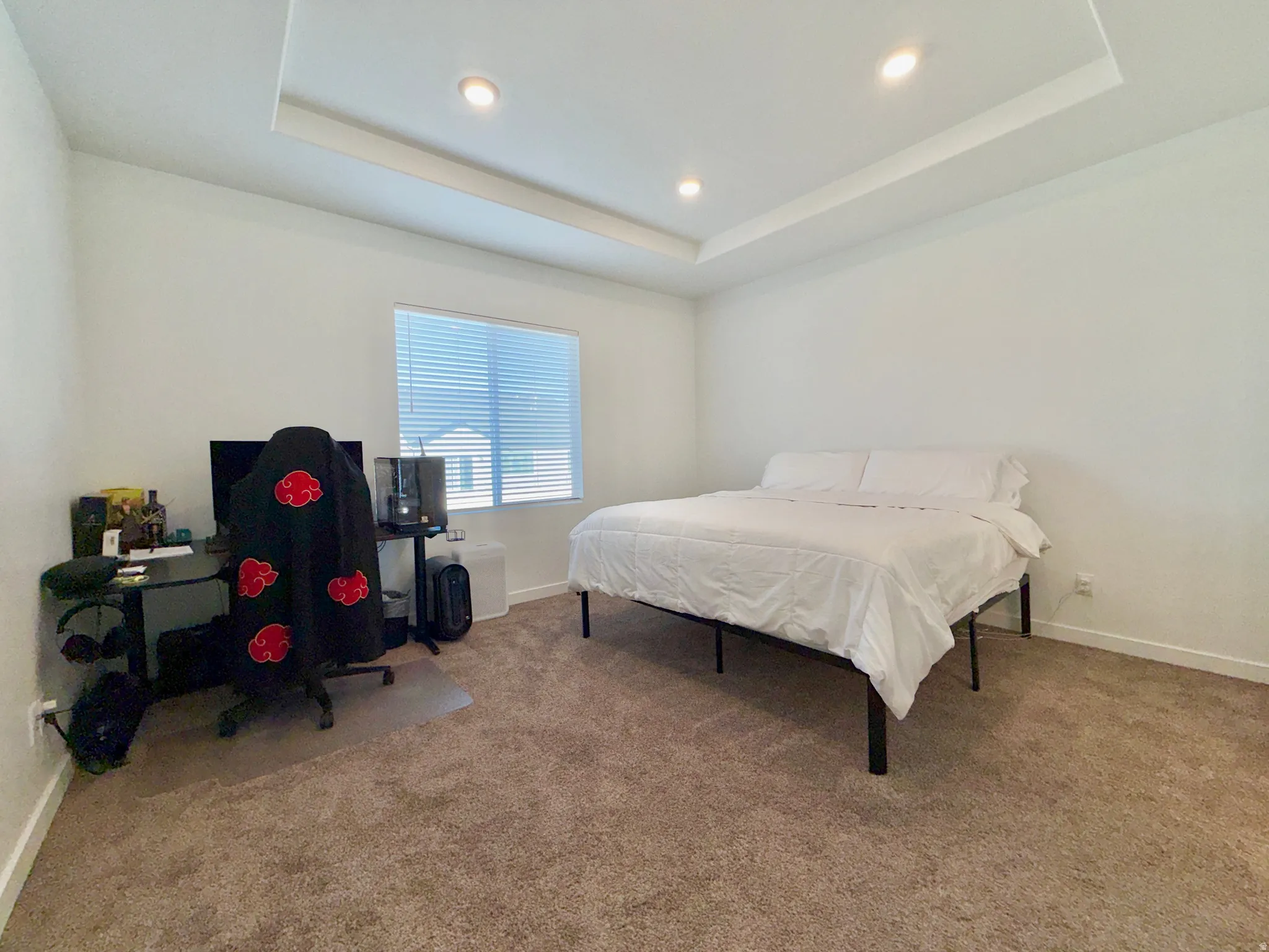Bedroom featuring light colored carpet, recessed lighting, and a raised ceiling