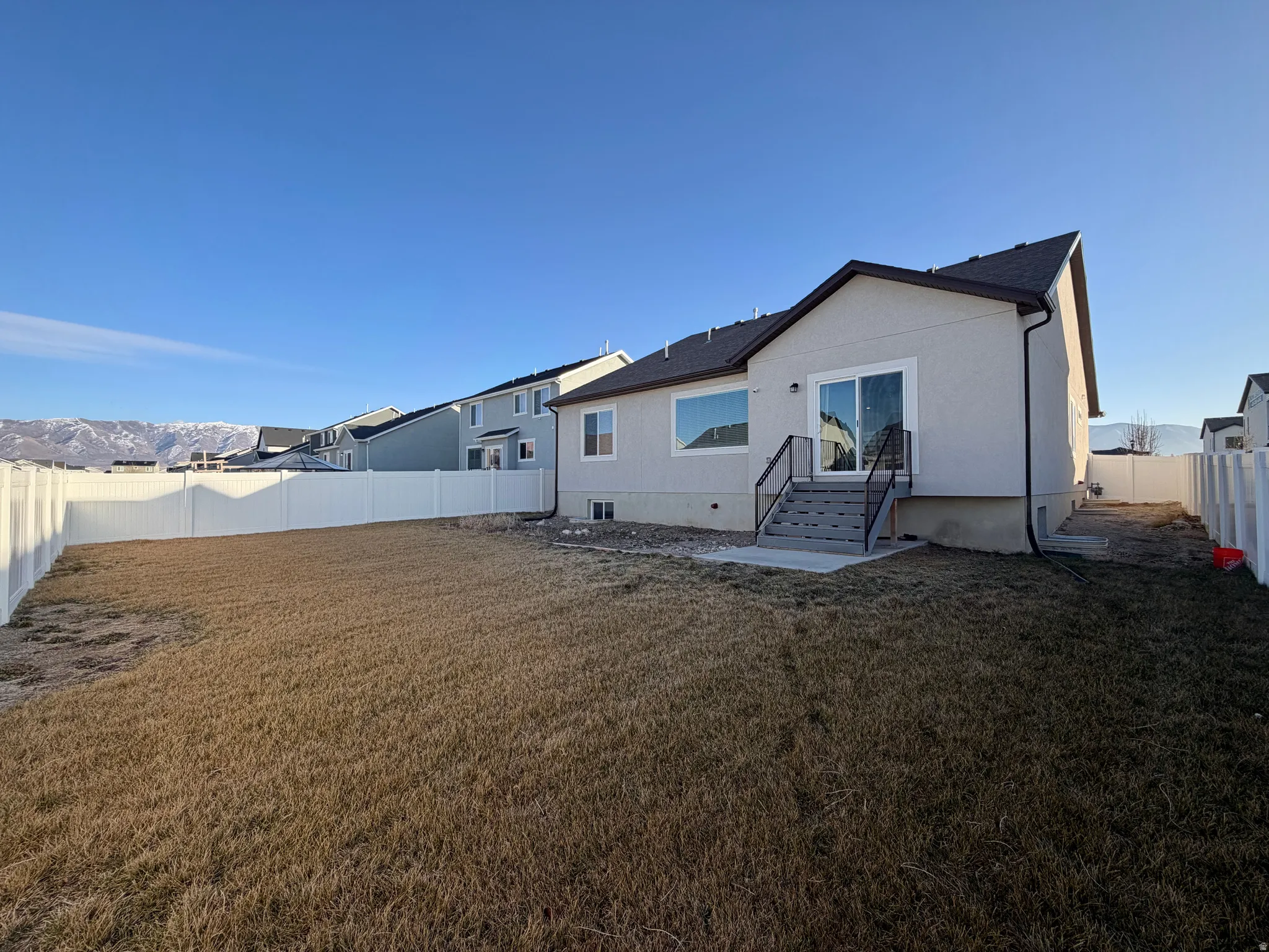 Rear view of house featuring a fenced backyard and stucco siding