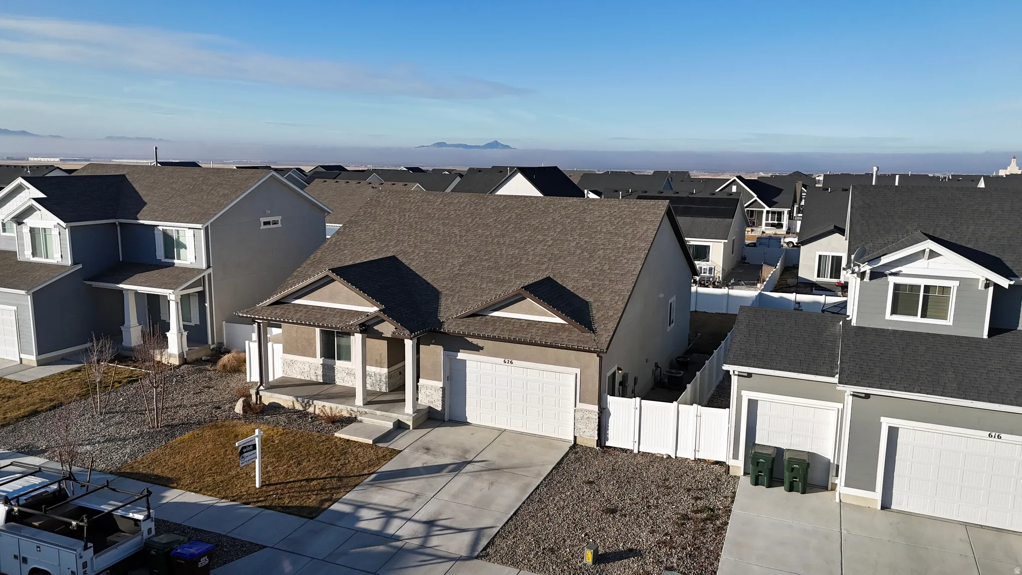 Traditional home featuring a garage, covered porch, a residential view, and driveway
