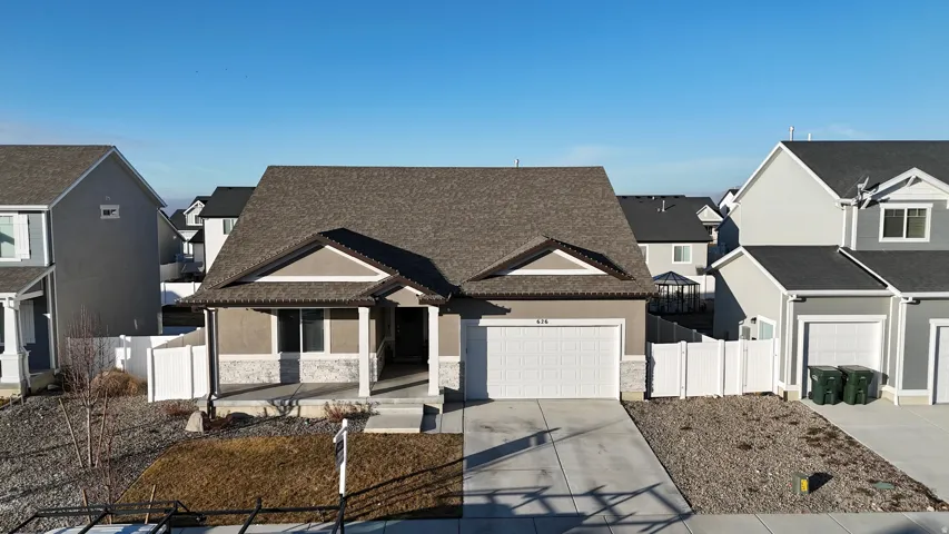 View of front of house with a residential view, concrete driveway, stone siding, stucco siding, and a garage