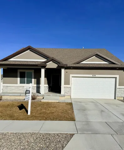 Ranch-style house featuring stucco siding, covered porch, concrete driveway, and a garage