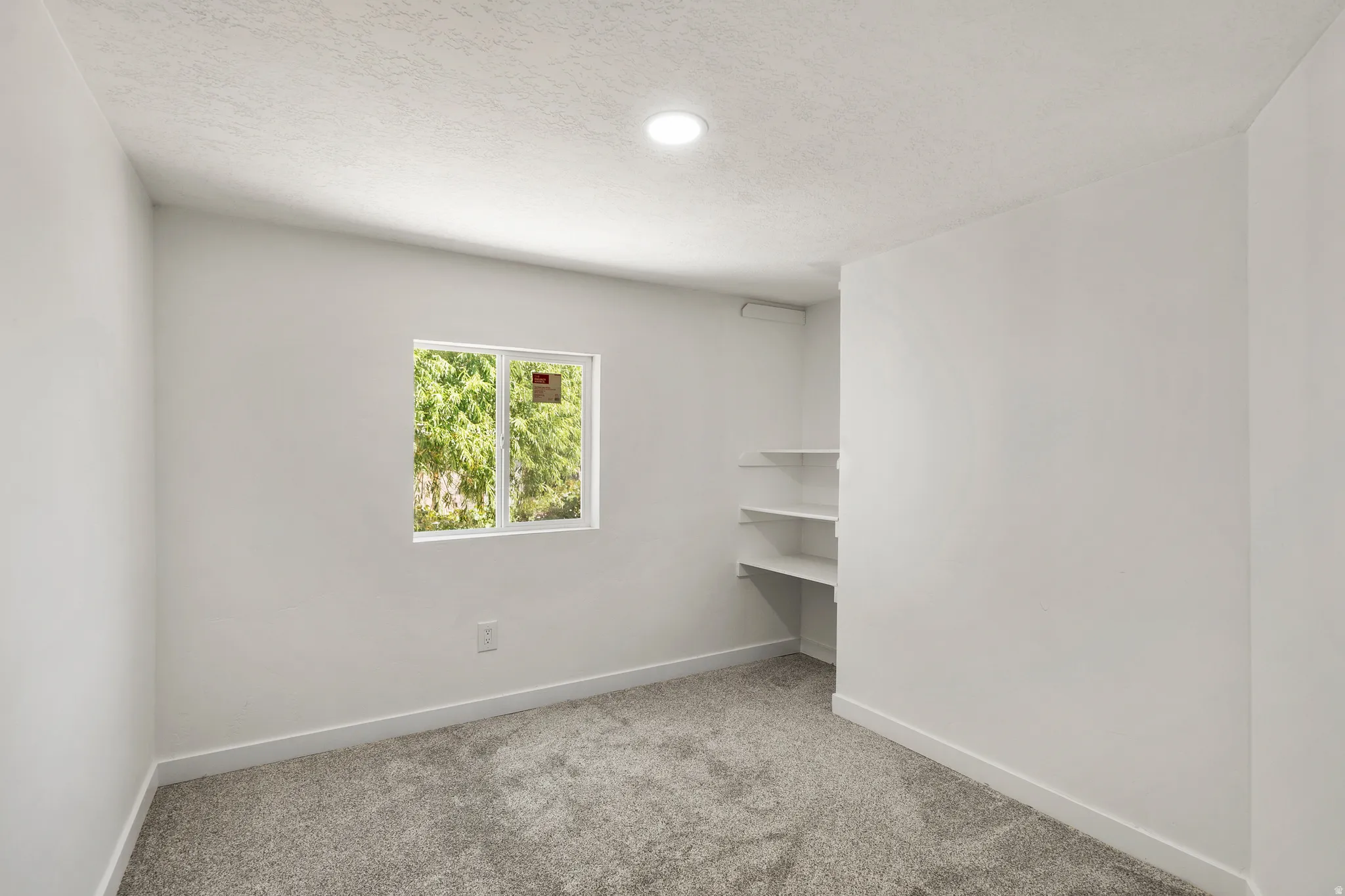 Unfurnished room with light carpet and a textured ceiling