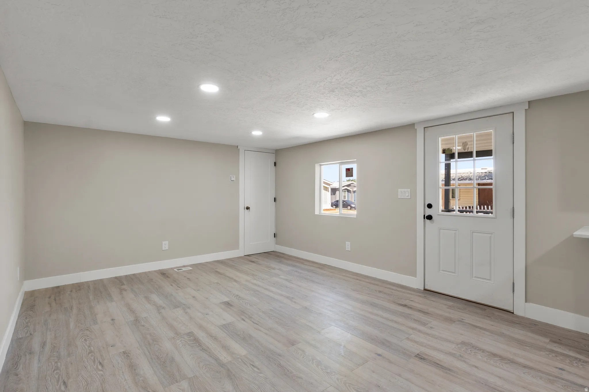 Foyer entrance featuring a textured ceiling, light wood-style floors, and recessed lighting