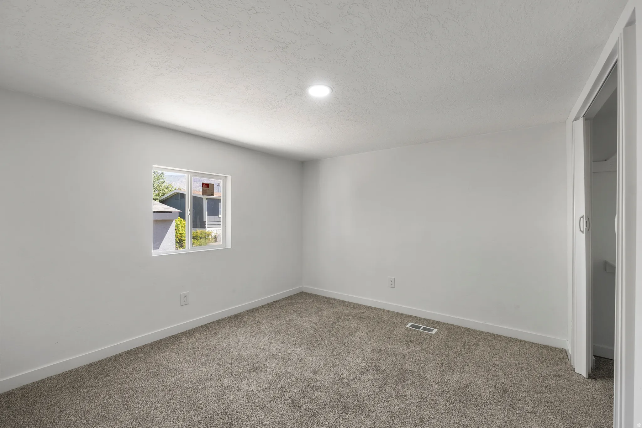 Unfurnished room featuring carpet and a textured ceiling