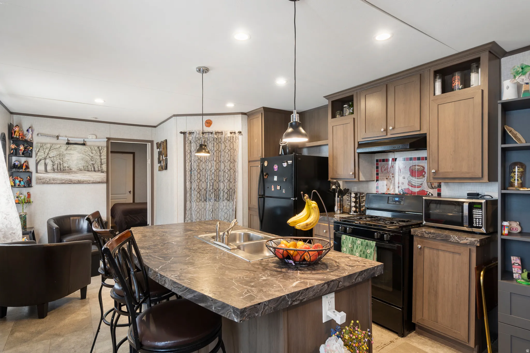Kitchen featuring open shelves, dark countertops, black appliances, a kitchen bar, and decorative light fixtures