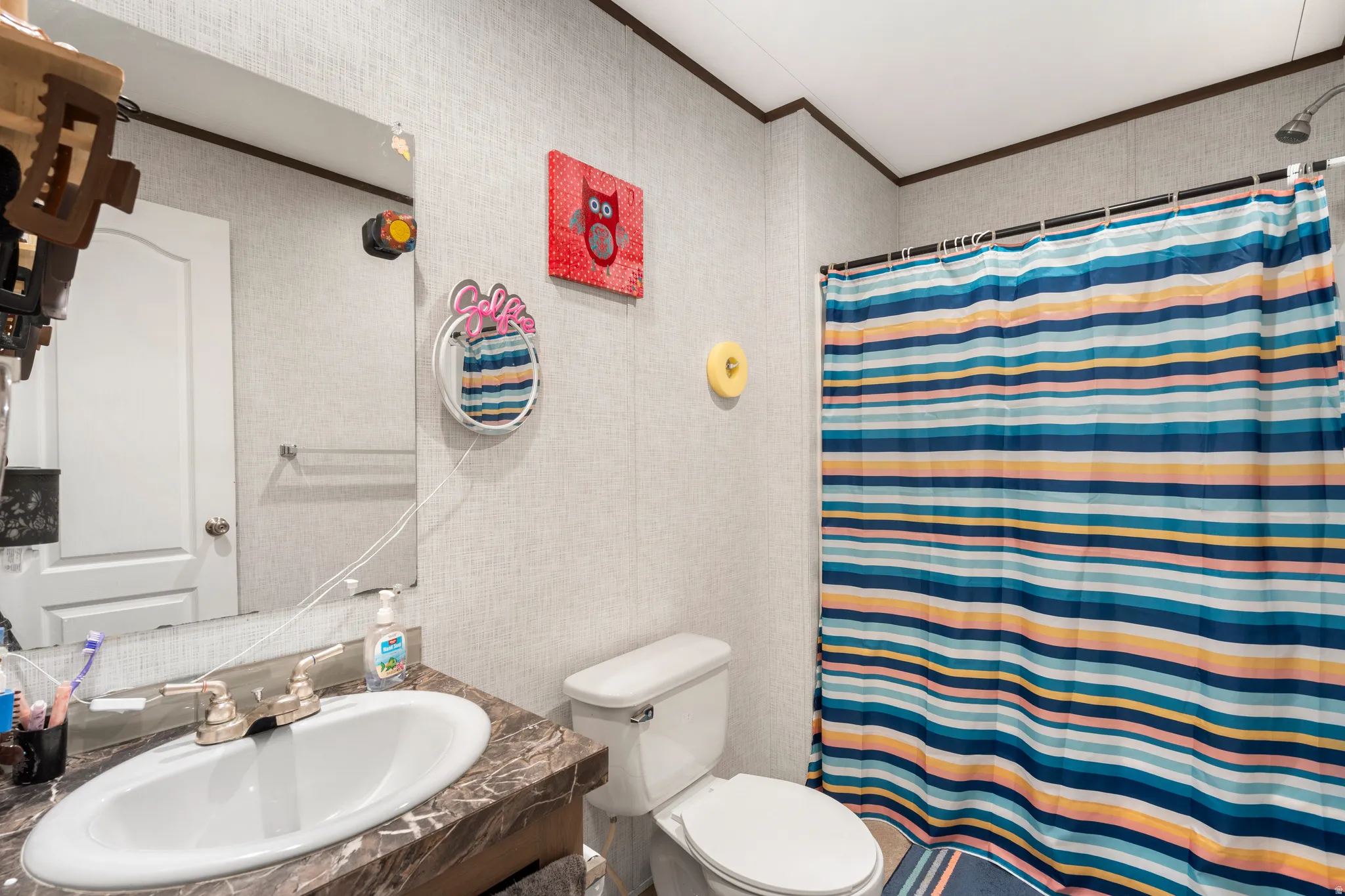 Full bathroom featuring a shower with shower curtain, vanity, and crown molding