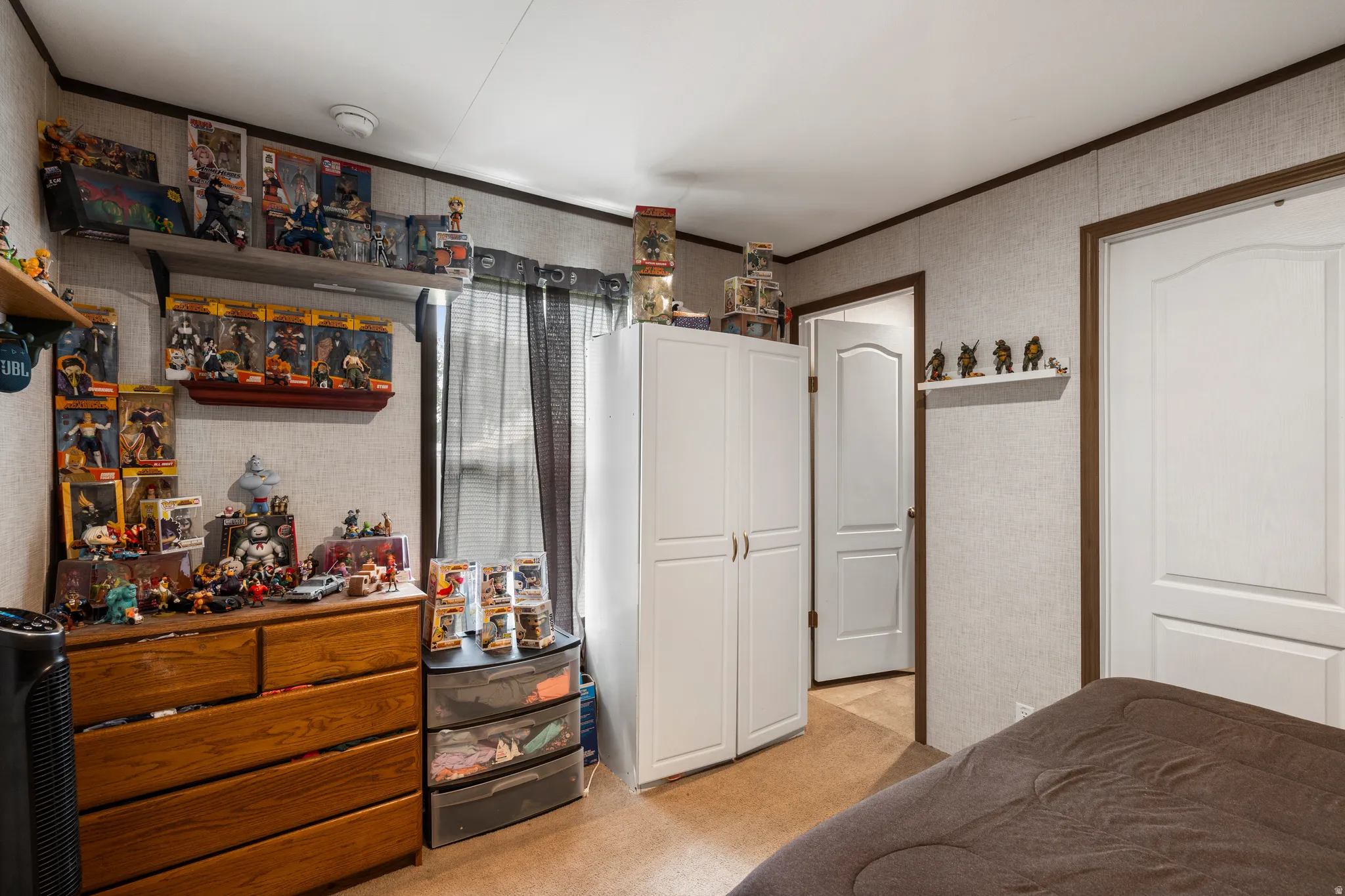 Bedroom featuring light colored carpet, ornamental molding, and wallpapered walls
