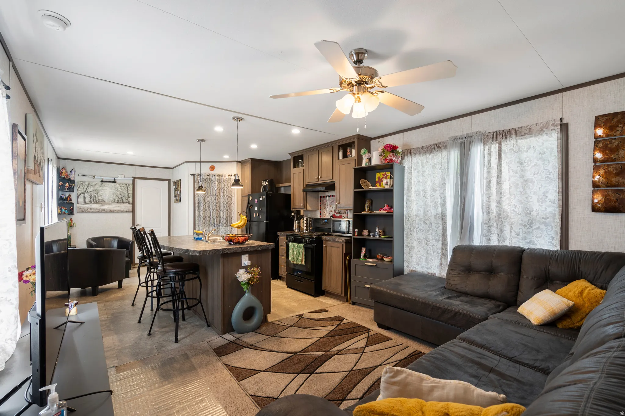 Living area with crown molding and a ceiling fan