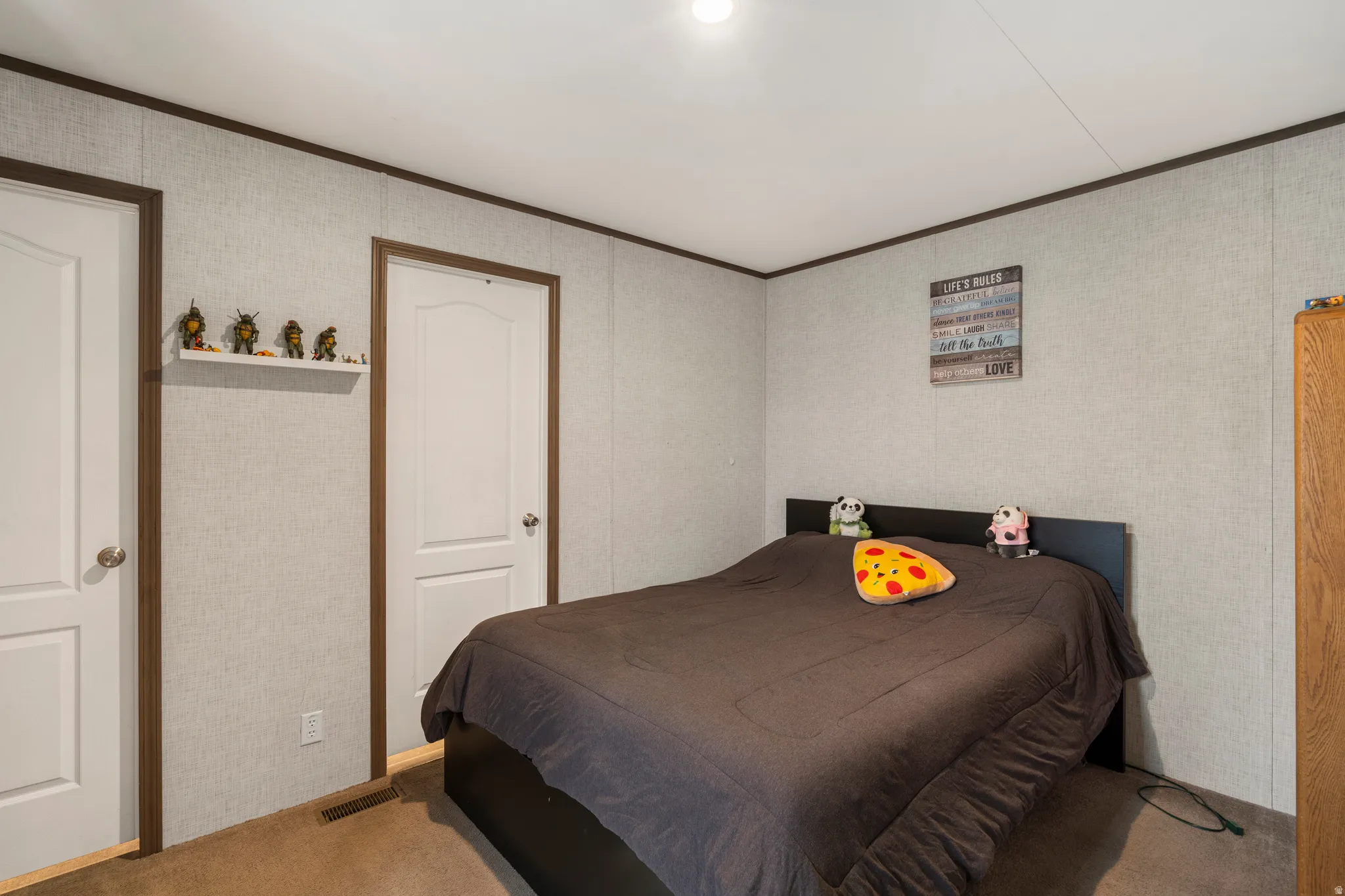Carpeted bedroom featuring crown molding