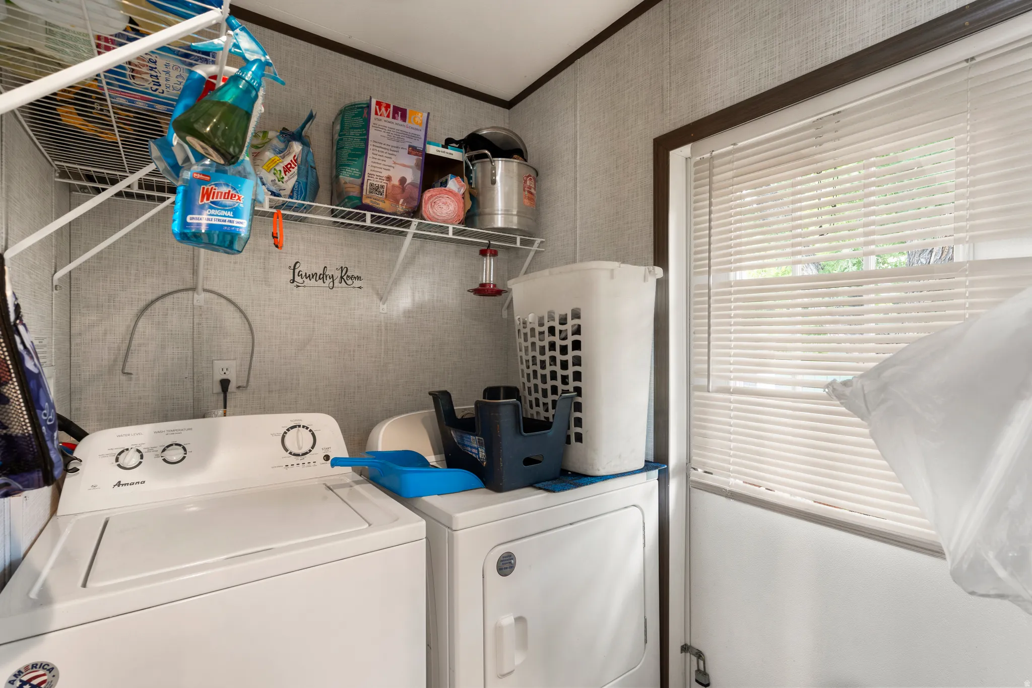 Washroom featuring washing machine and clothes dryer and crown molding