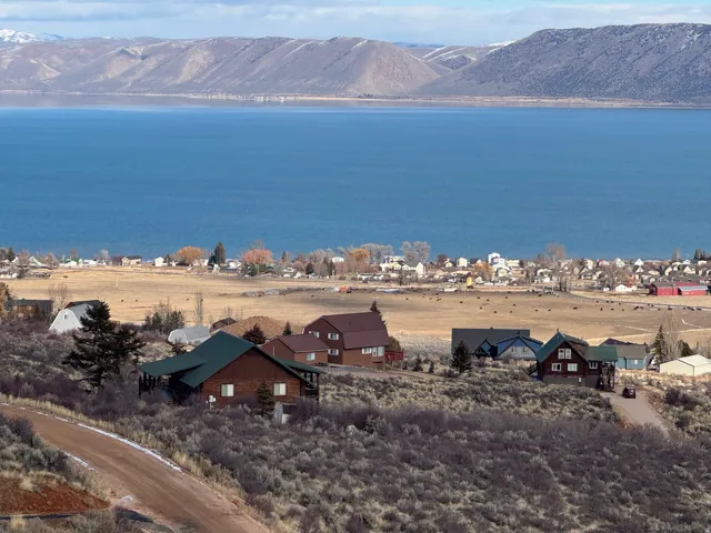 Water view featuring a mountain backdrop and nearby suburban area
