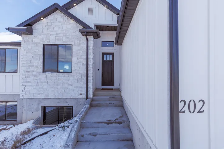 Doorway to property featuring stone siding and board and batten siding