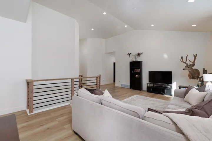 Living room featuring light wood-type flooring, recessed lighting, and high vaulted ceiling
