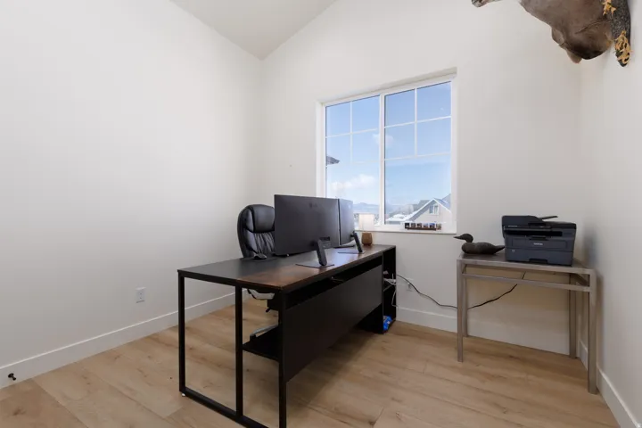 Office featuring light wood-type flooring and vaulted ceiling