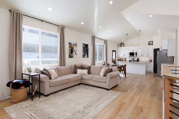 Living area with light wood-style flooring, recessed lighting, and high vaulted ceiling