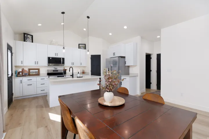Dining space featuring light wood-style flooring and high vaulted ceiling