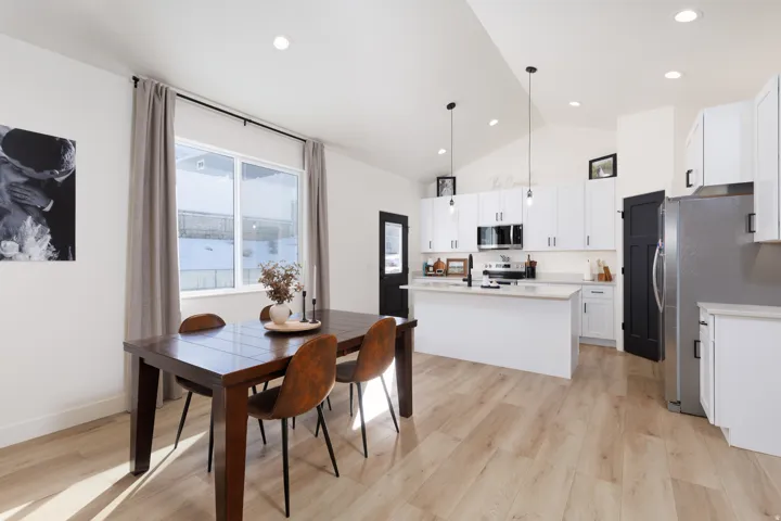Dining space featuring light wood finished floors, high vaulted ceiling, and recessed lighting