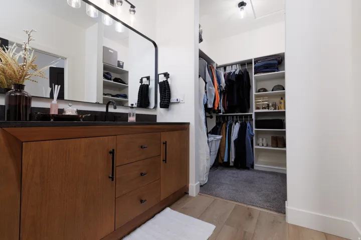 Full bath featuring vanity, light wood-type flooring, and a walk in closet