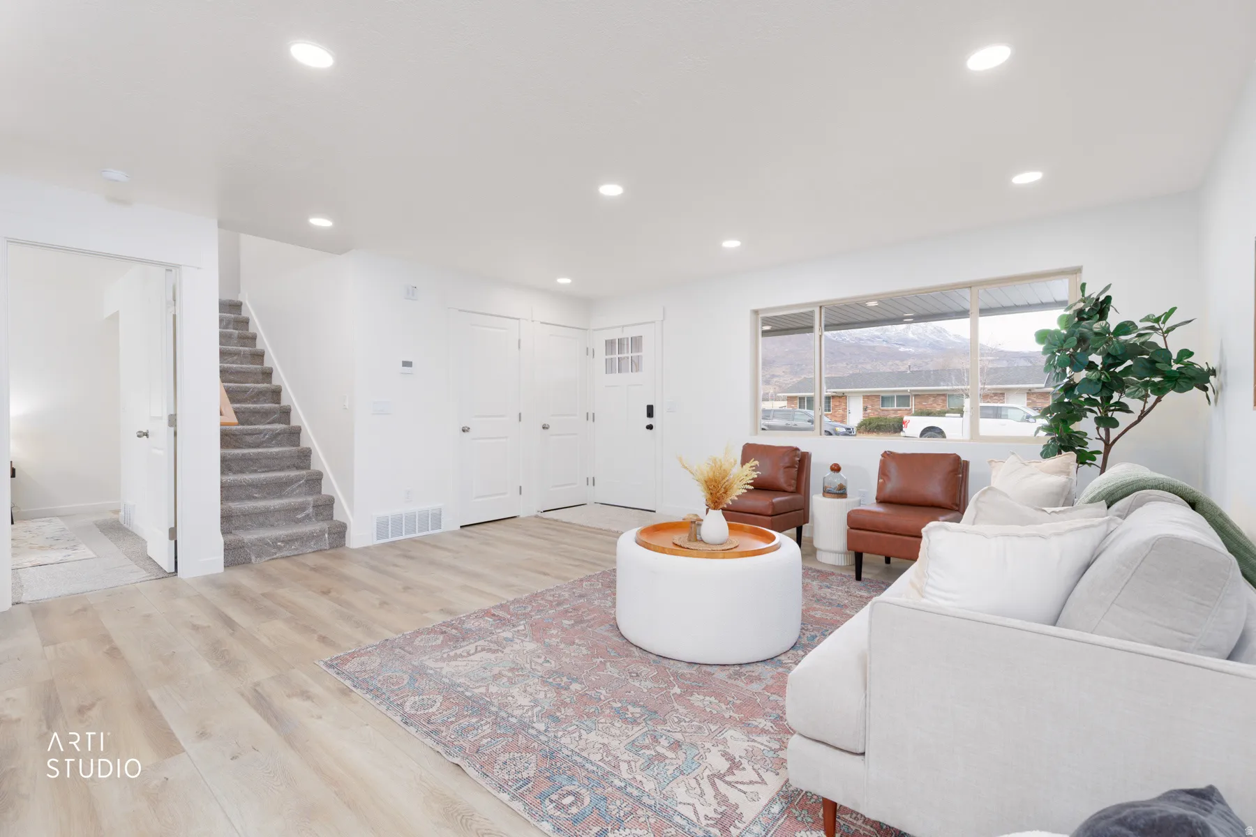 Living room with light wood-type flooring and recessed lighting
