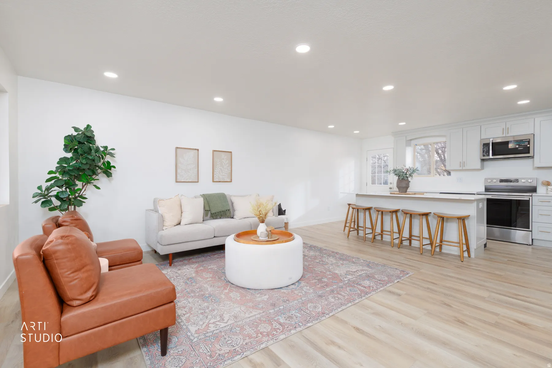 Living room with light wood finished floors and recessed lighting