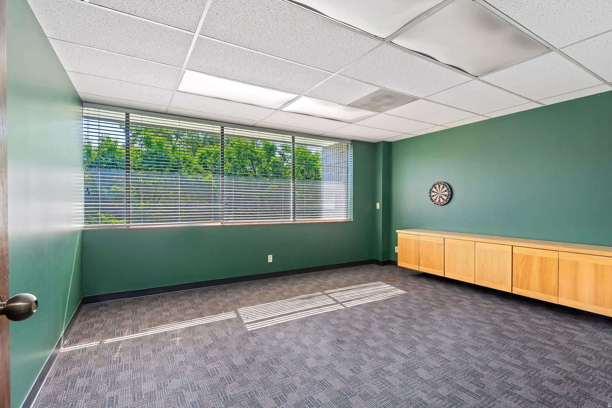 Empty room with dark colored carpet and a paneled ceiling