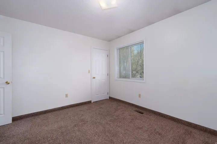 Spare room with dark carpet and a textured ceiling