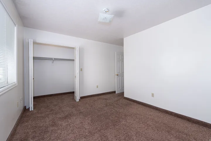 Unfurnished bedroom featuring dark colored carpet and a textured ceiling