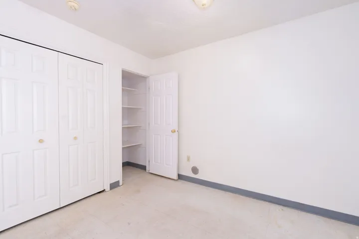 Unfurnished bedroom featuring a closet and light floors