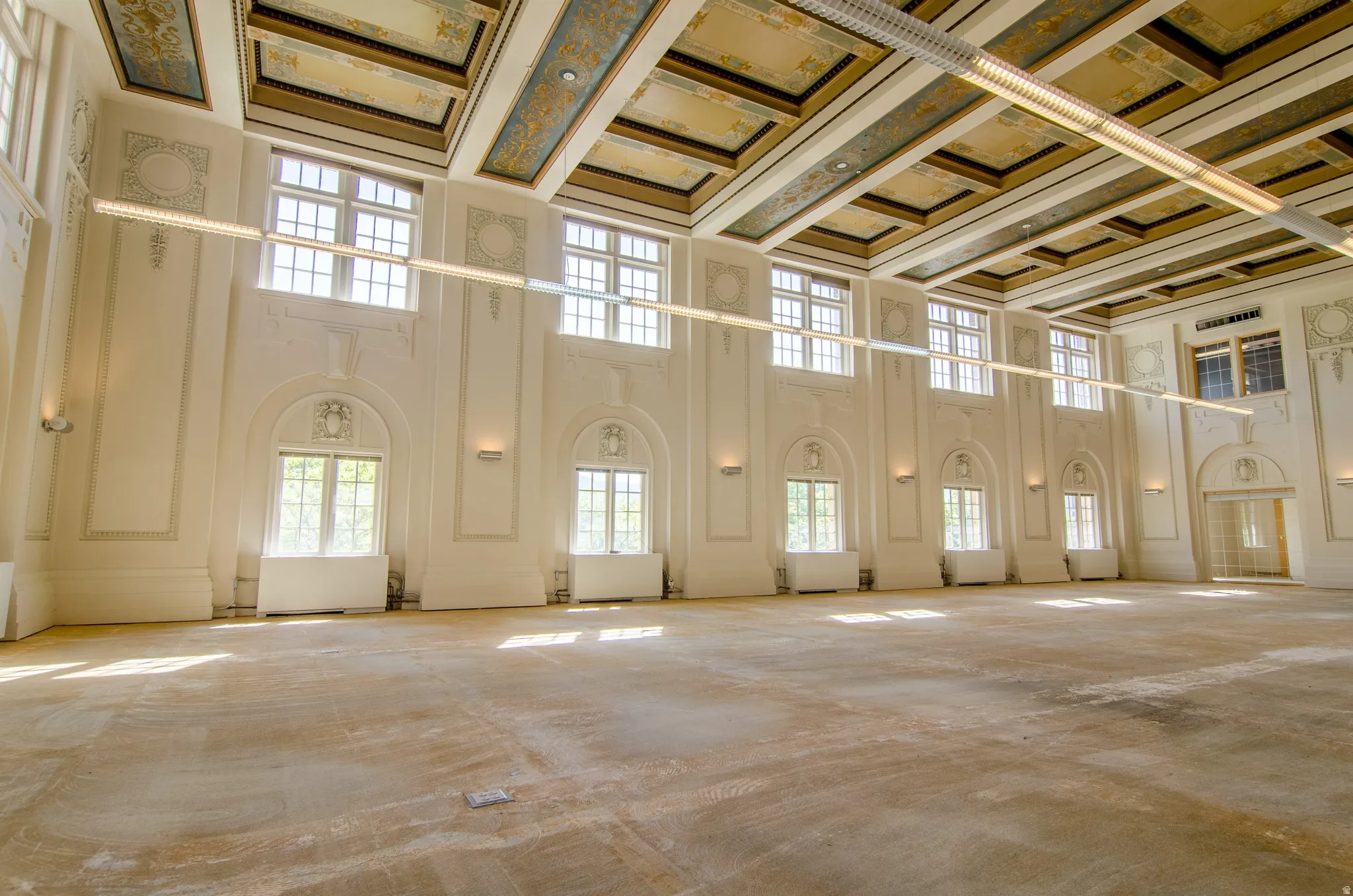 Miscellaneous room with coffered ceiling, a towering ceiling, beamed ceiling, a decorative wall, and crown molding