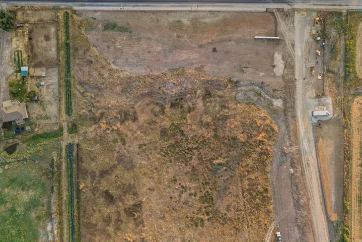 Extensive undeveloped land parcel featuring existing access roads and utility infrastructure