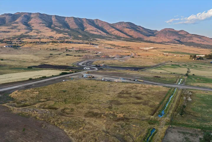 Expansive agricultural property featuring irrigated cropland with established water delivery infrastructure, bordered by a well-maintained access road