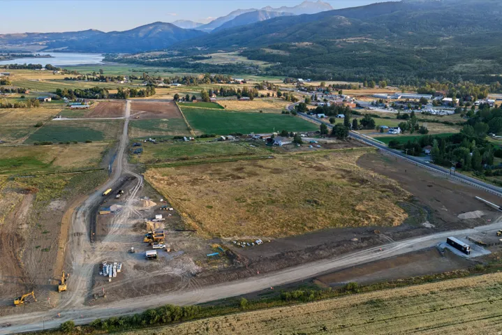 Expansive development-ready property featuring cleared and graded land with active construction infrastructure, paved road access, and utility connections