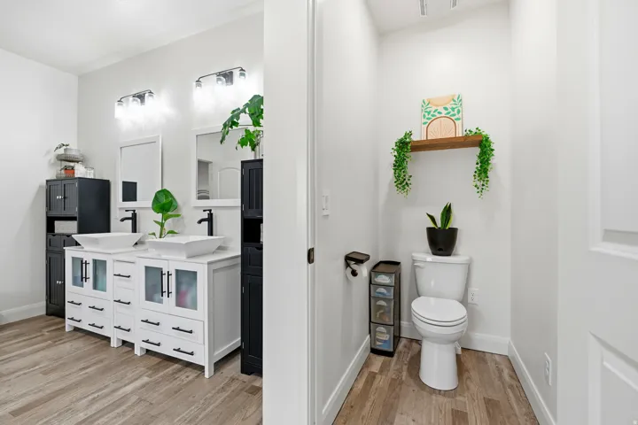 Bathroom with double vanity and light wood-style flooring
