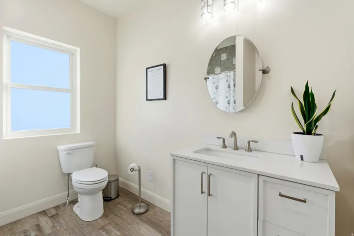 Full bath featuring vanity, a shower with curtain, and light wood-style floors