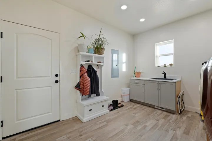 Mudroom featuring light wood-style flooring, recessed lighting, electric panel, and washer / clothes dryer