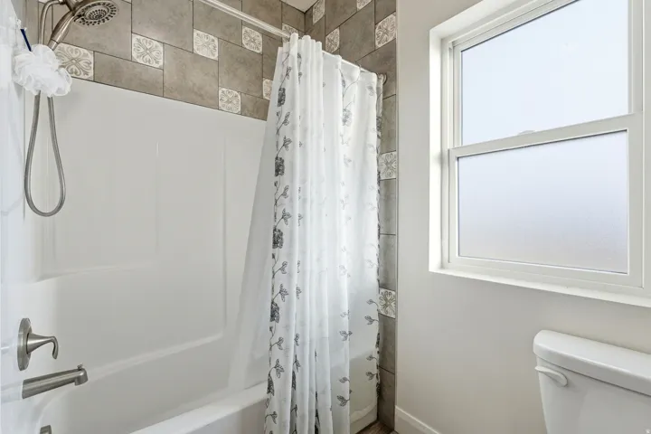 Full bathroom featuring shower / tub combo and toilet