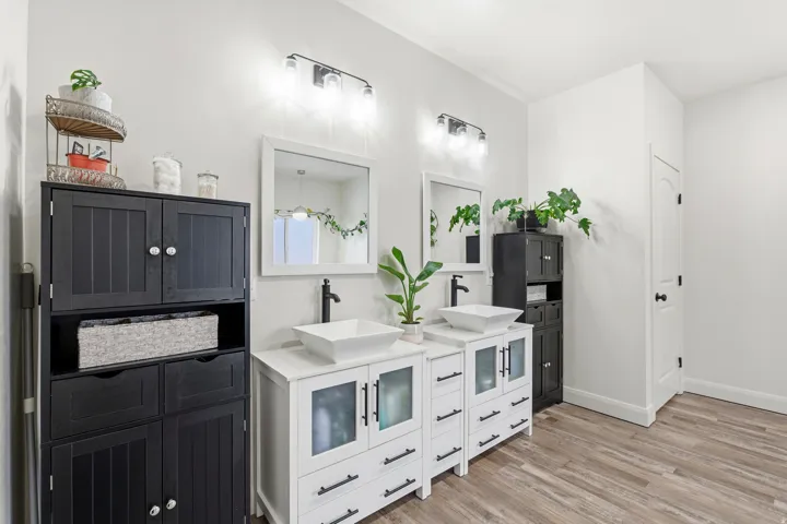 Kitchen with light wood-type flooring, white cabinetry, and dark cabinets