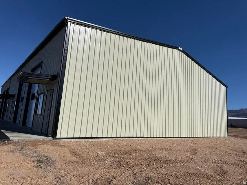View of side of property with a pole building and an outbuilding