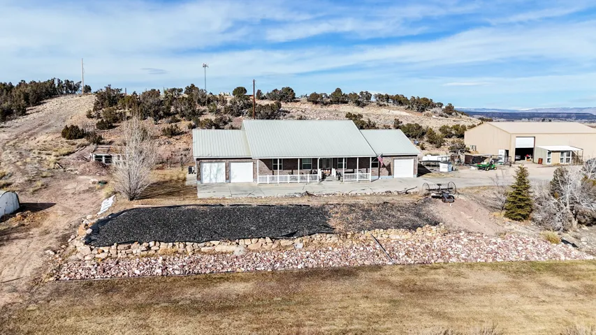 Rear view of house featuring a patio, a metal roof, and an attached garage