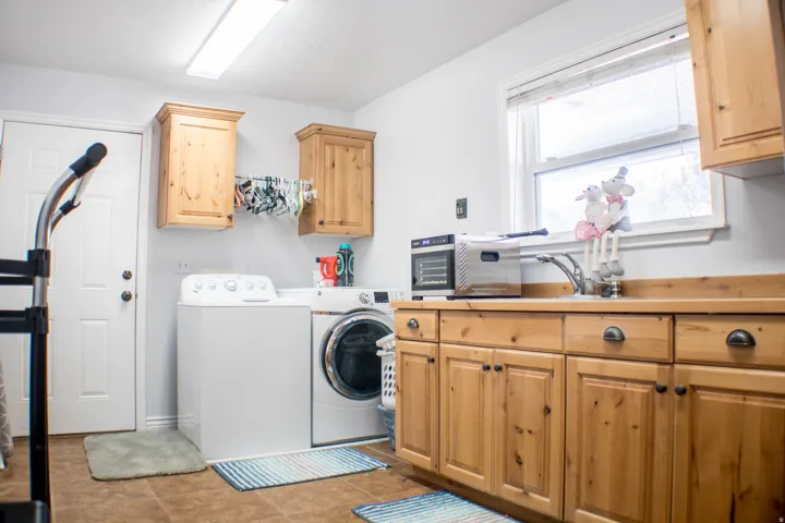 Washroom featuring cabinet space and washing machine and dryer