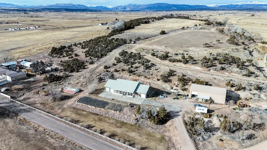 Aerial view of property and surrounding area featuring mountains and rural landscape