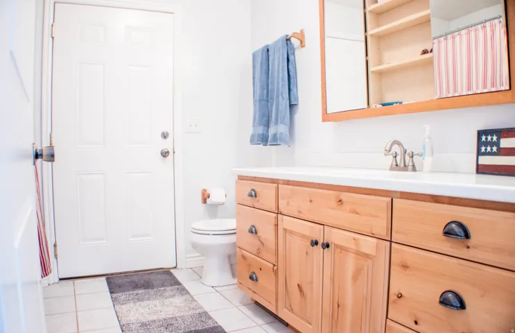 Full bathroom featuring vanity, light tile patterned floors, and a shower with shower curtain