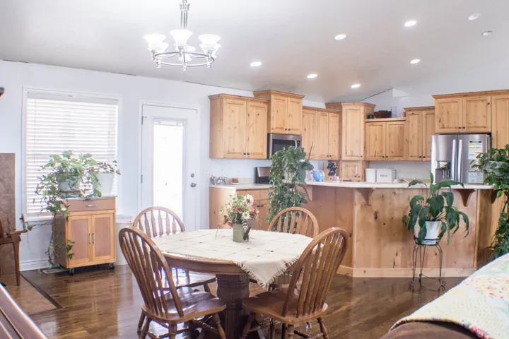 Dining room featuring dark wood-type flooring, recessed lighting, a chandelier, and lofted ceiling