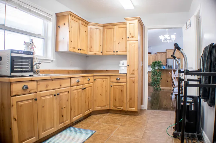 Kitchen featuring light brown cabinets, light countertops, light tile patterned floors, and a chandelier
